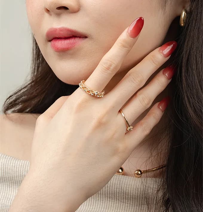 Hand-drawn nail art in a warm red on almond nails